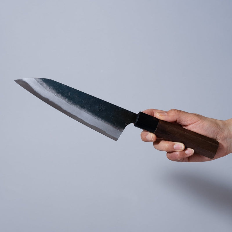 Hand holding a Nishida Hamono Kurouchi Gyuto Knife 165mm