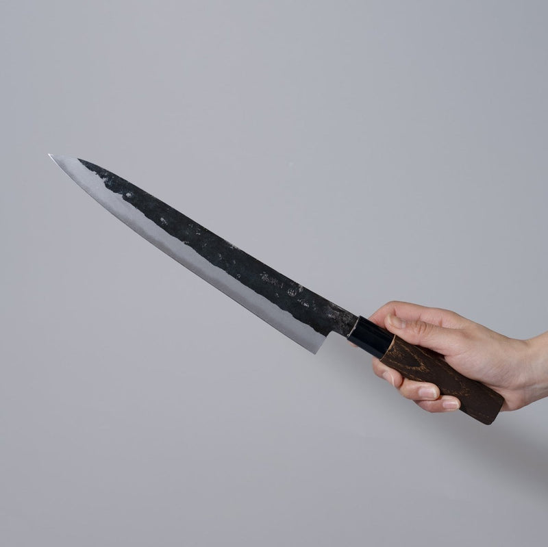Hand holding a Nakamura Hamono Kurouchi Sashimi Knife 240mm