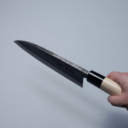 Hand holding a Nakamura Hamono Kurouchi Deba Knife 210mm