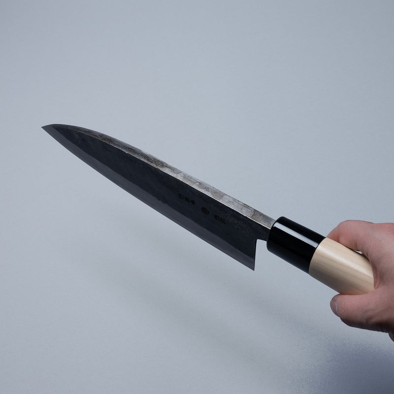 Hand holding a Nakamura Hamono Kurouchi Deba Knife 210mm