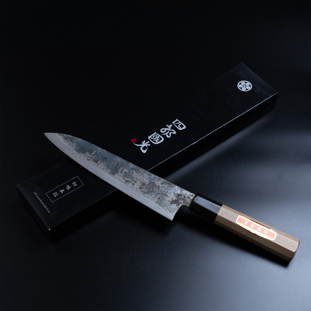 Shirou Kunimitsu Special White Steel Kurouchi Gyuto Knife 210mm in front of the black box with the artisan name in Japanese characters