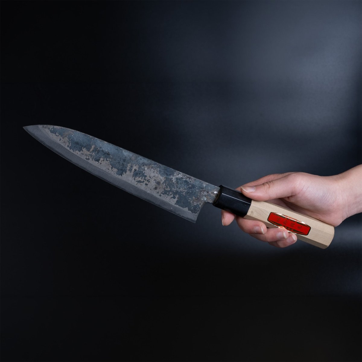 Hand holding a Shirou Kunimitsu Special White Steel Kurouchi Gyuto Knife 210mm