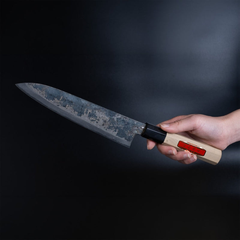 Hand holding a Shirou Kunimitsu Special White Steel Kurouchi Gyuto Knife 210mm