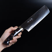 Hand holding Takeshi Saji VG-10W Stainless Steel Nakiri 170mm on a dark background
