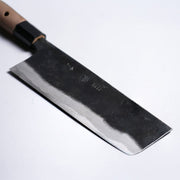 Closeup on tip of Kyohei Shindo Kurouchi Nakiri 170mm crafted from Aogami 2 in Kochi, Japan on grey background
