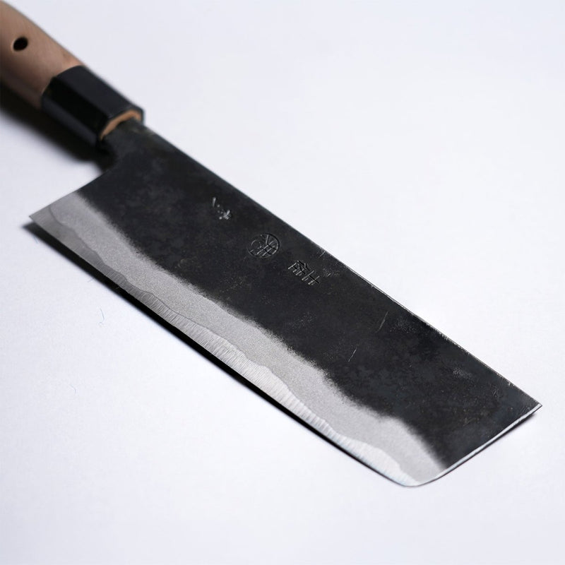 Closeup on tip of Kyohei Shindo Kurouchi Nakiri 170mm crafted from Aogami 2 in Kochi, Japan on grey background