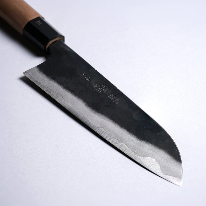 Closeup on tip of Kyohei Shindo Kurouchi Santoku 170mm crafted from Aogami 2 in Kochi, Japan on grey background