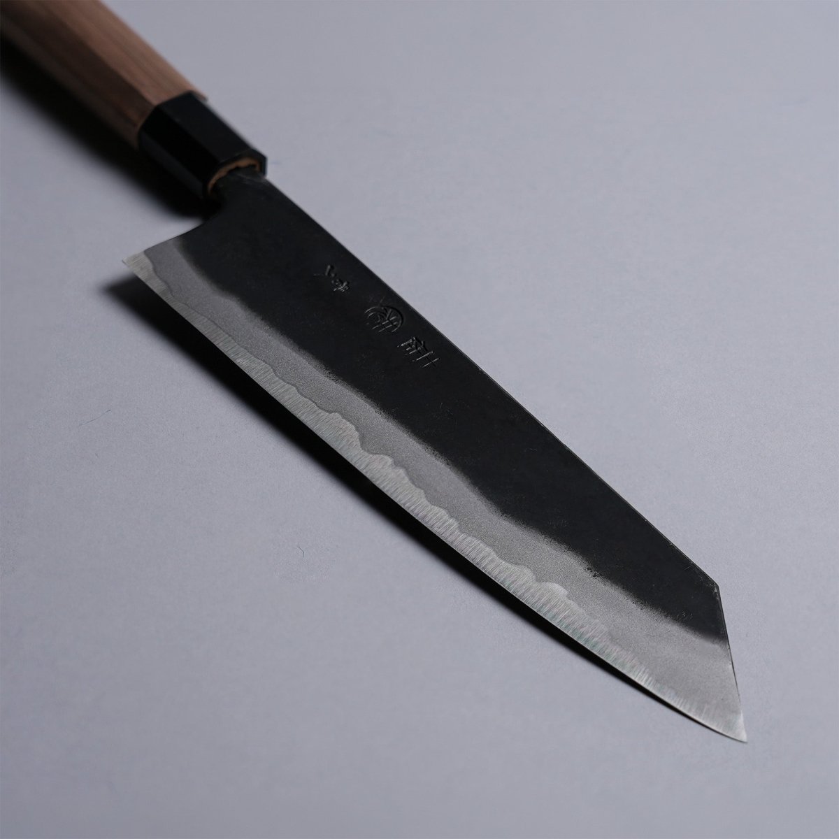 Closeup on tip of Kyohei Shindo Kurouchi Kiritsuke Gyuto 220mm crafted from Aogami 2 in Kochi, Japan on grey background