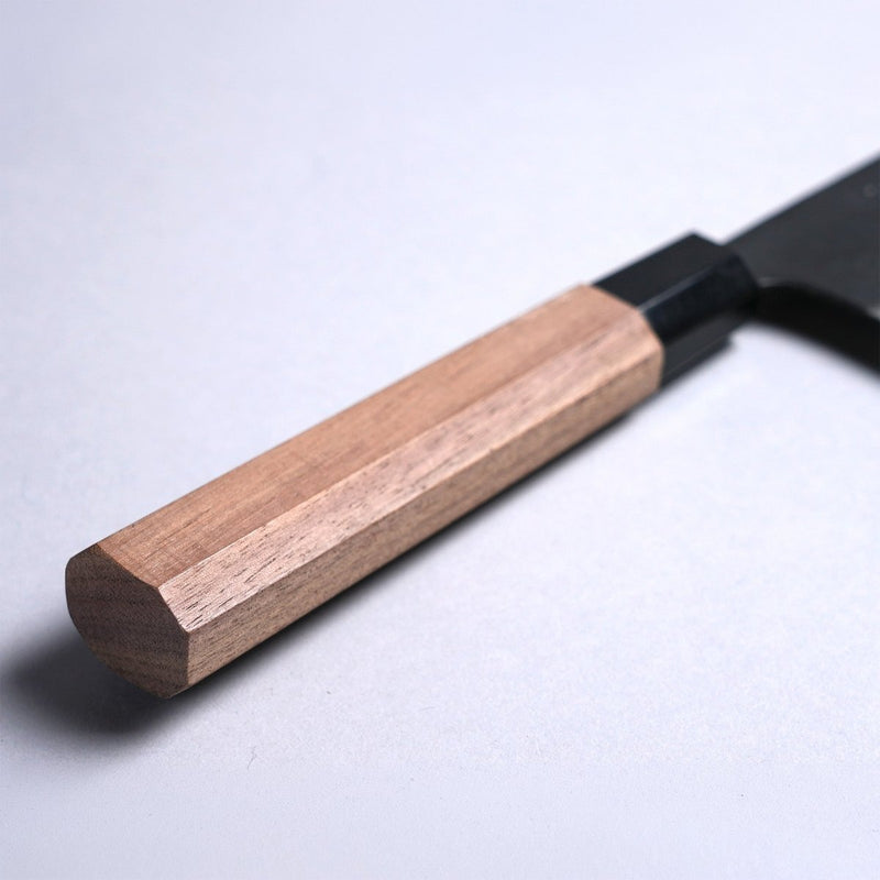 Closeup on handle of Kyohei Shindo Kurouchi Gyuto 220mm crafted from Aogami 2 in Kochi Japan on grey background