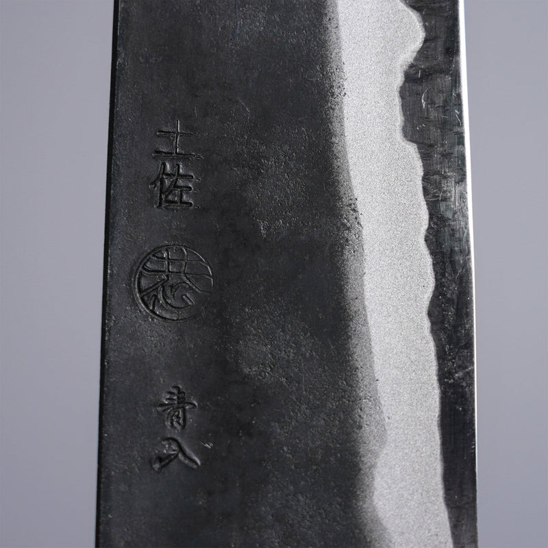 Closeup on engraving on Kyohei Shindo Kurouchi Gyuto 220mm crafted from Aogami 2 in Kochi Japan on grey background