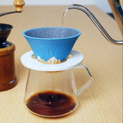 Metal kettle pouring hot water into Ceramic Coffee Filter COFIL Mt. Fuji over a coffee pot
