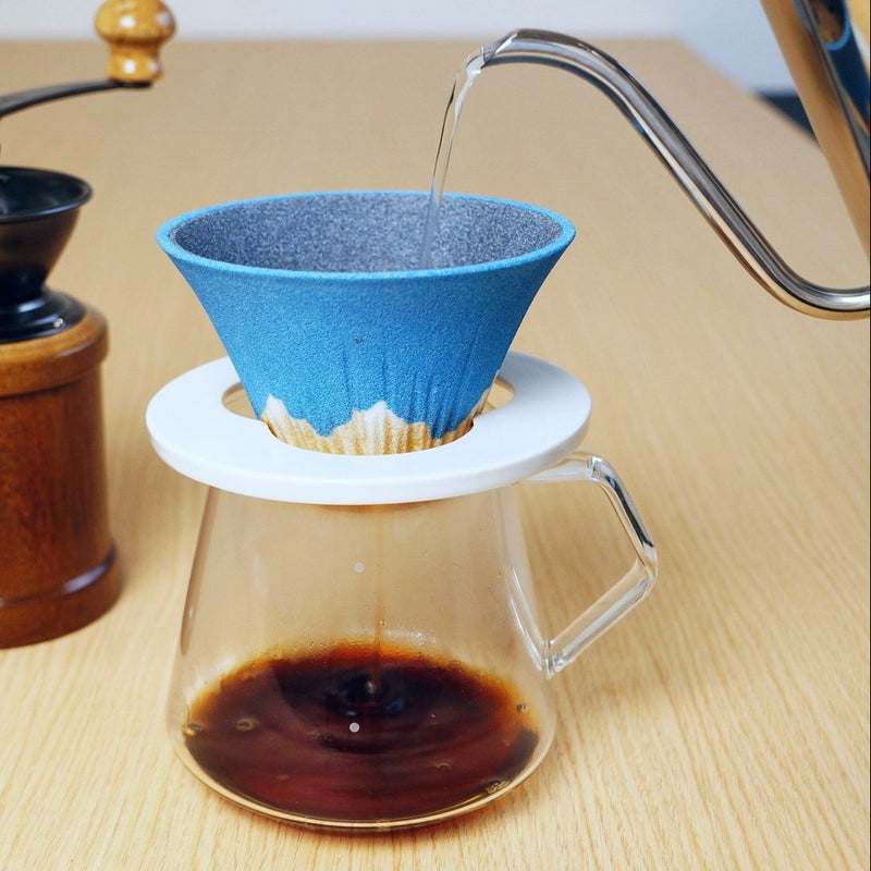 Metal kettle pouring hot water into Ceramic Coffee Filter COFIL Mt. Fuji over a coffee pot
