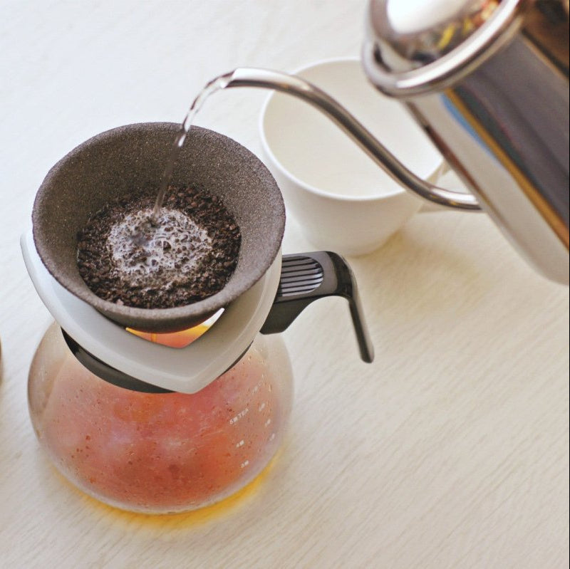 Metal kettle pouring hot water over coffee grounds in Ceramic Coffee Filter COFIL Standard