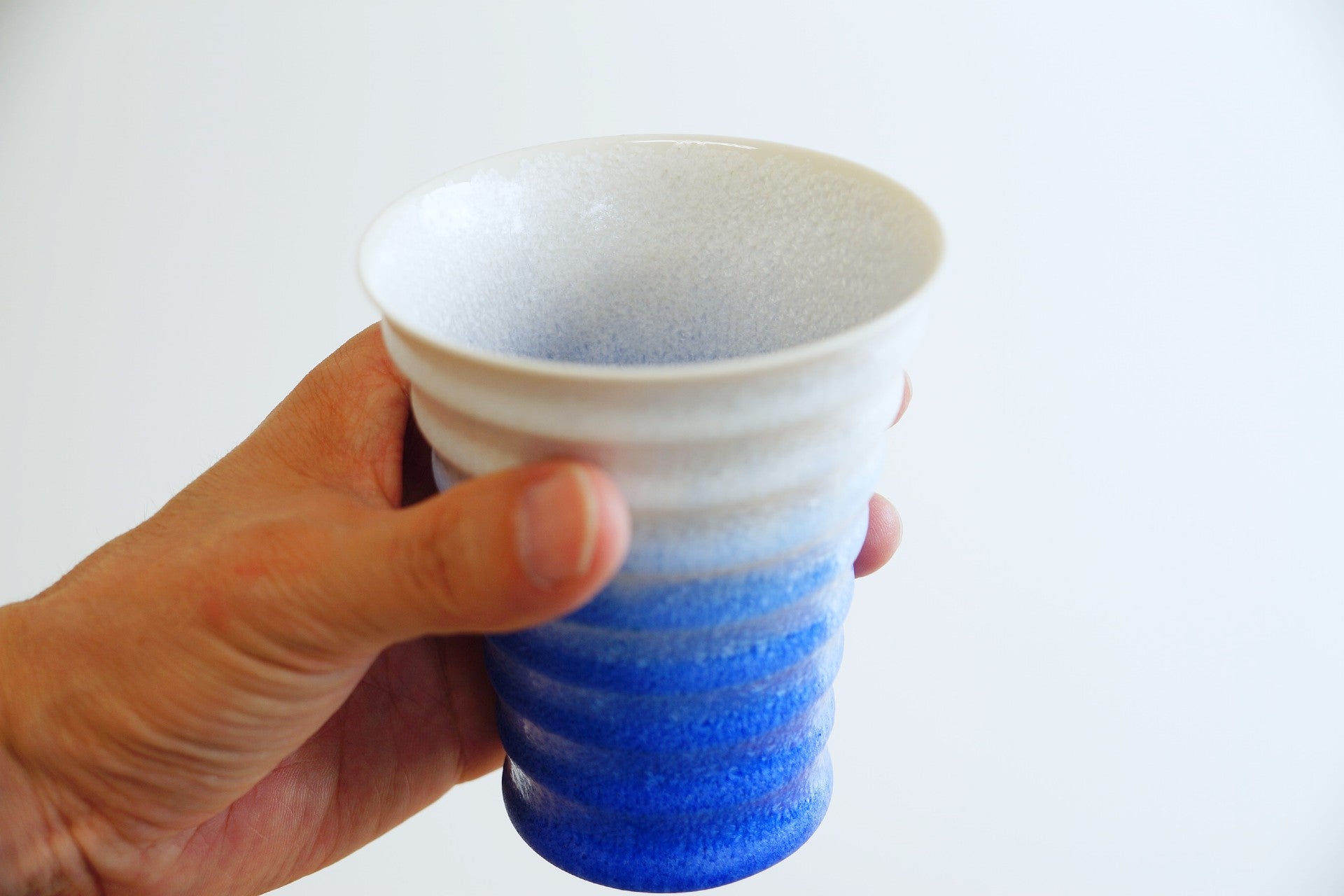 Indigo ceramic cup in a hand