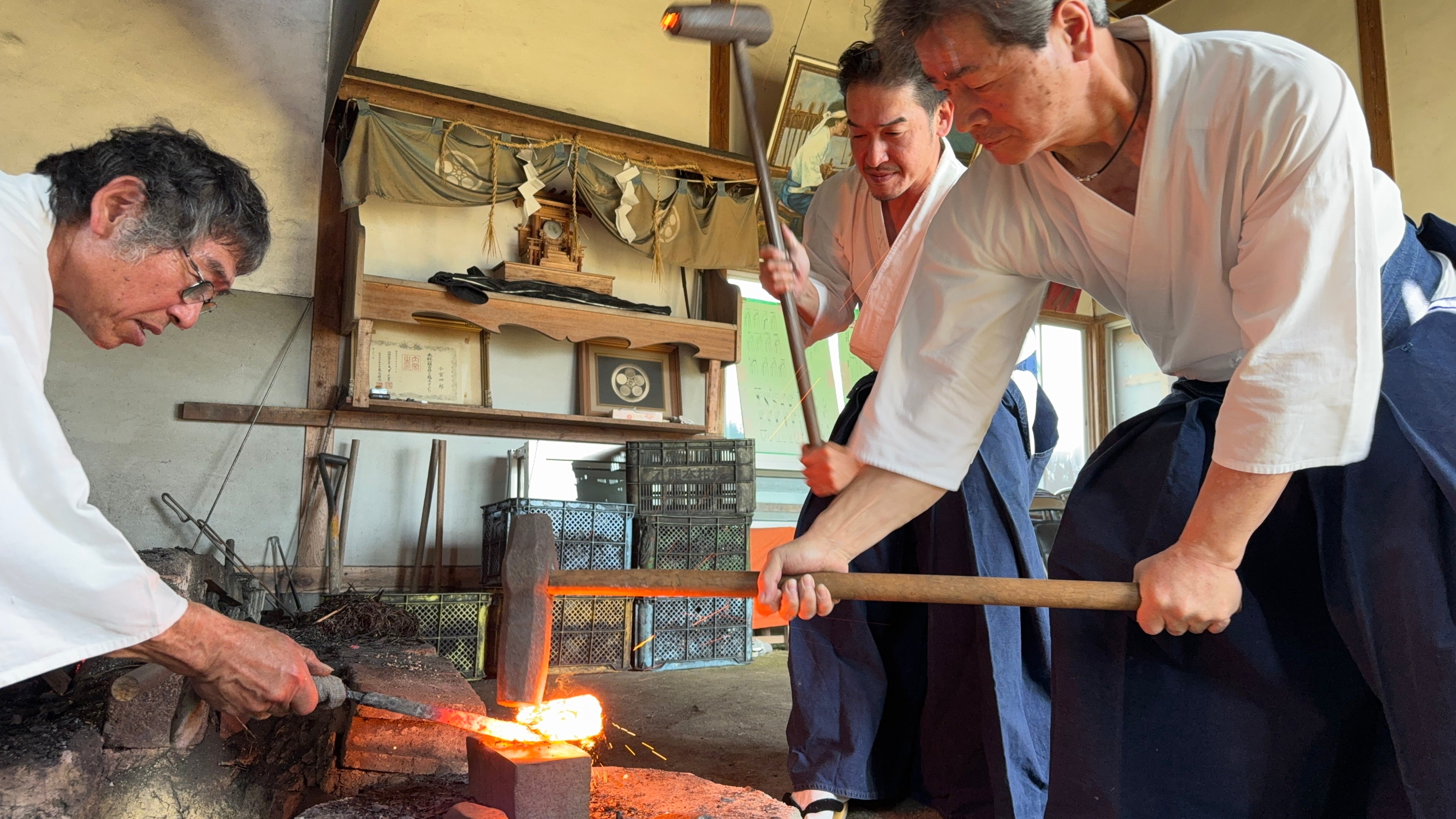 Shirou Kunimitsu artisans at work in traditional hakama clothes hammering a heated metal the traditional way