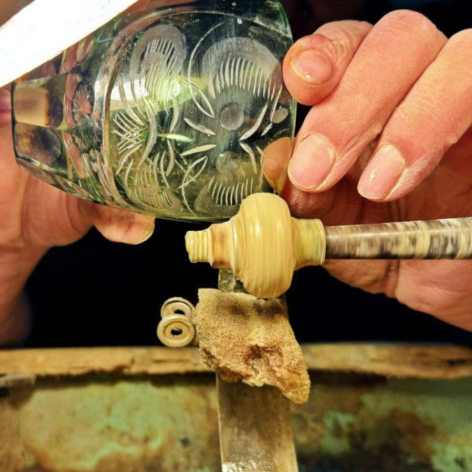 Close-up of Green Daruma Edo Kiriko Glass by Ootomo Glassware being polished