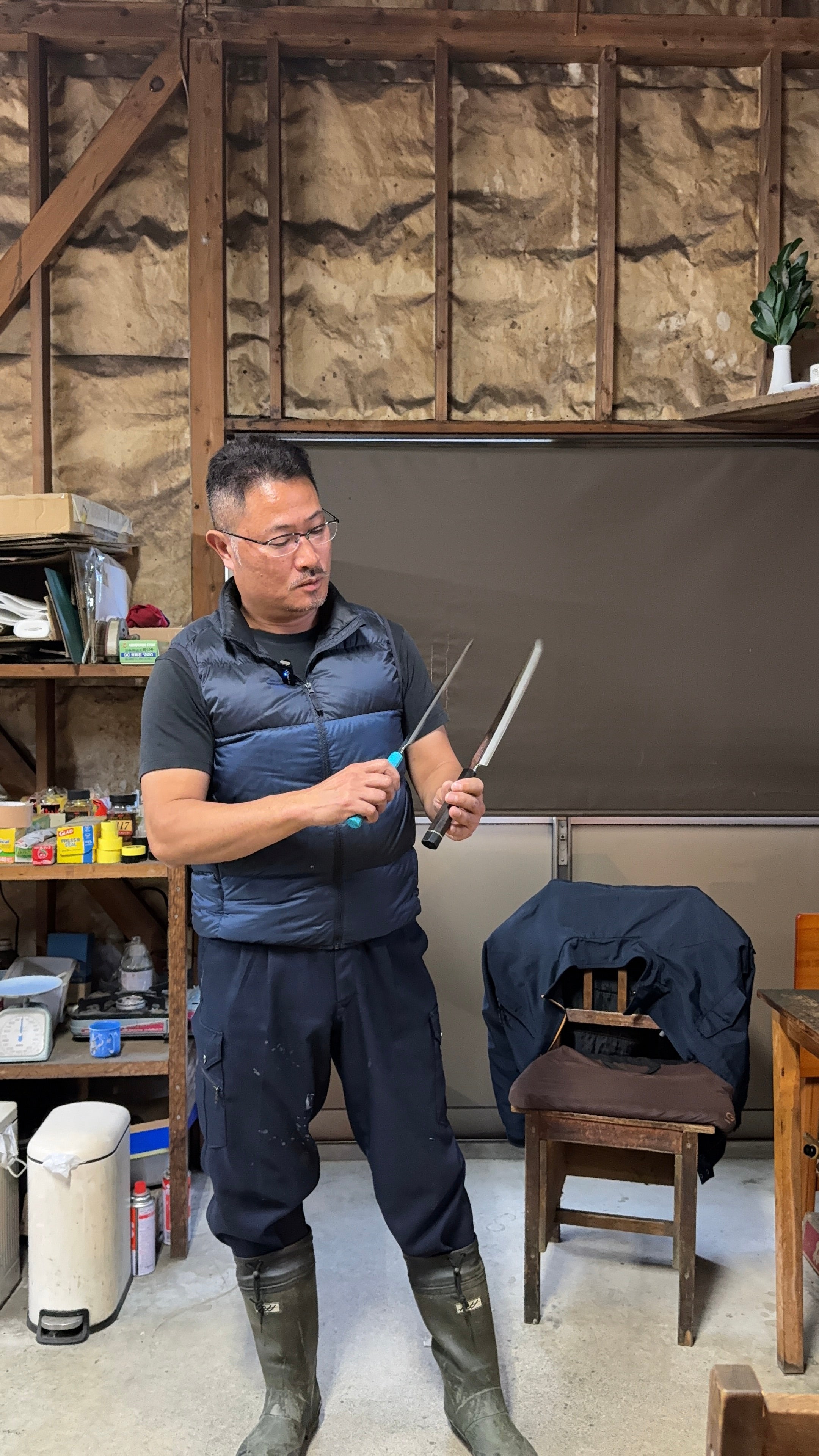 Makoto Tadokoro from Tadokoro Hamono looking at two of his blades
