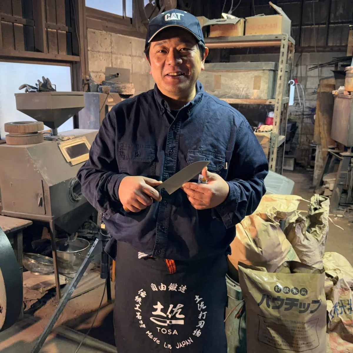 Portrait of Kajihara Hamono master artisan holding a balde in his hands