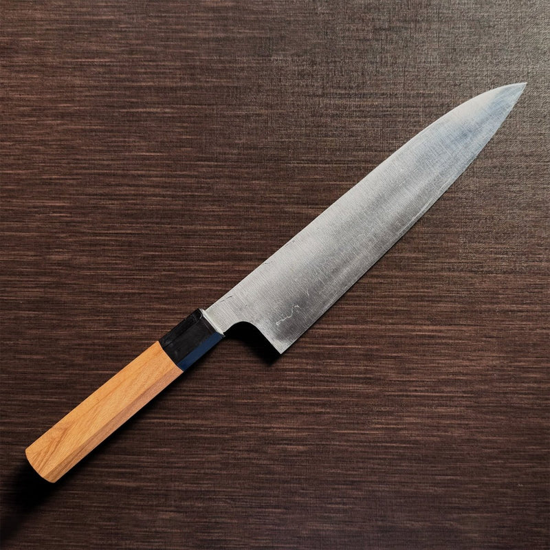 Bizen Osafune Tamahagane Gyuto Knife 212mm at an angle showcasing the folded steel blade surface and magnolia wood handle
