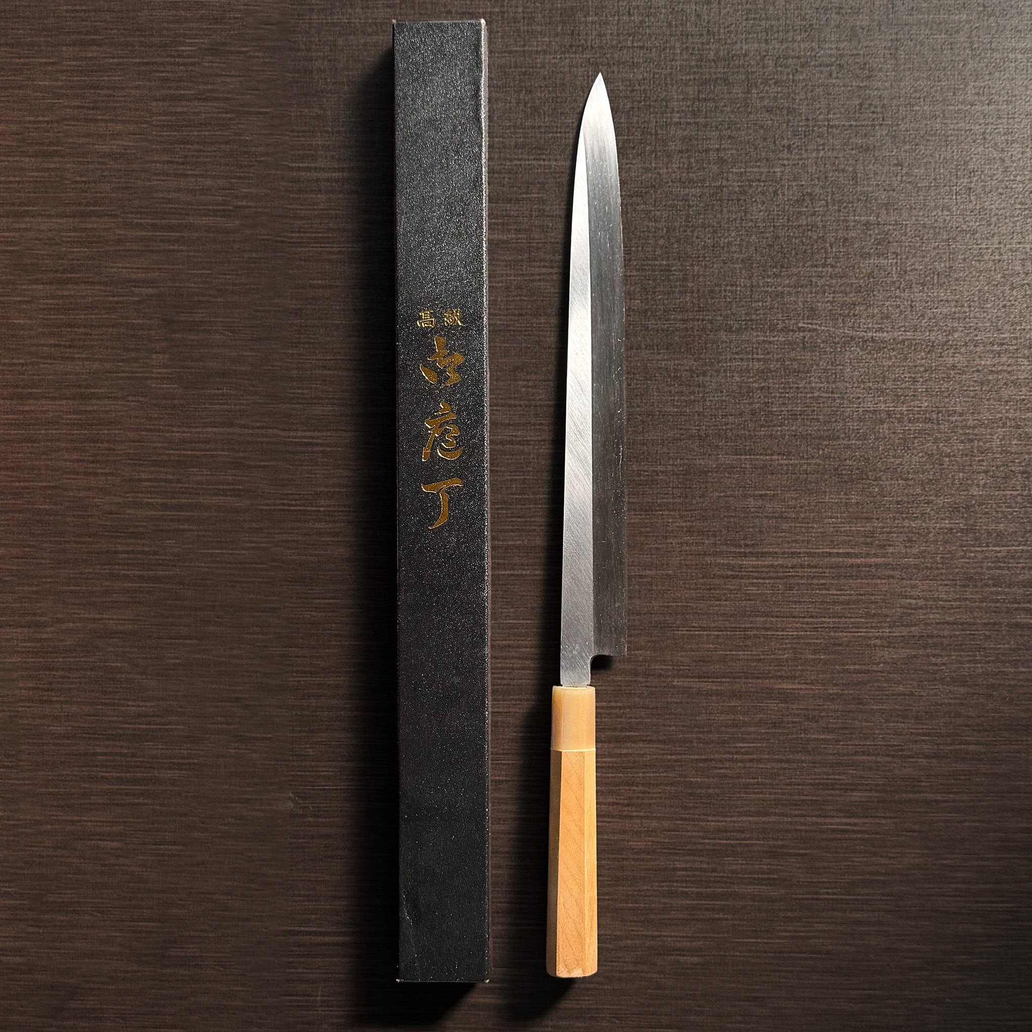 Bizen Osafune Tamahagane Sashimi Knife 310mm displayed next to its black presentation box with gold Japanese calligraphy