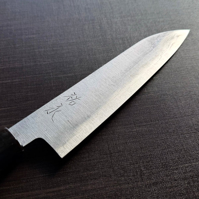 Close-up of the Bizen Osafune Tamahagane Santoku Knife 175mm blade showing the jihada folded steel grain and engraved 祐定 signature