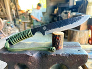 Minomo Blacksmith Ignite Knife 110mm displayed in a piece of wood inside the workshop