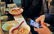 屋台慶次ラーメン作り体験に参加後、ラーメン丼の写真を撮るお客様のアップ