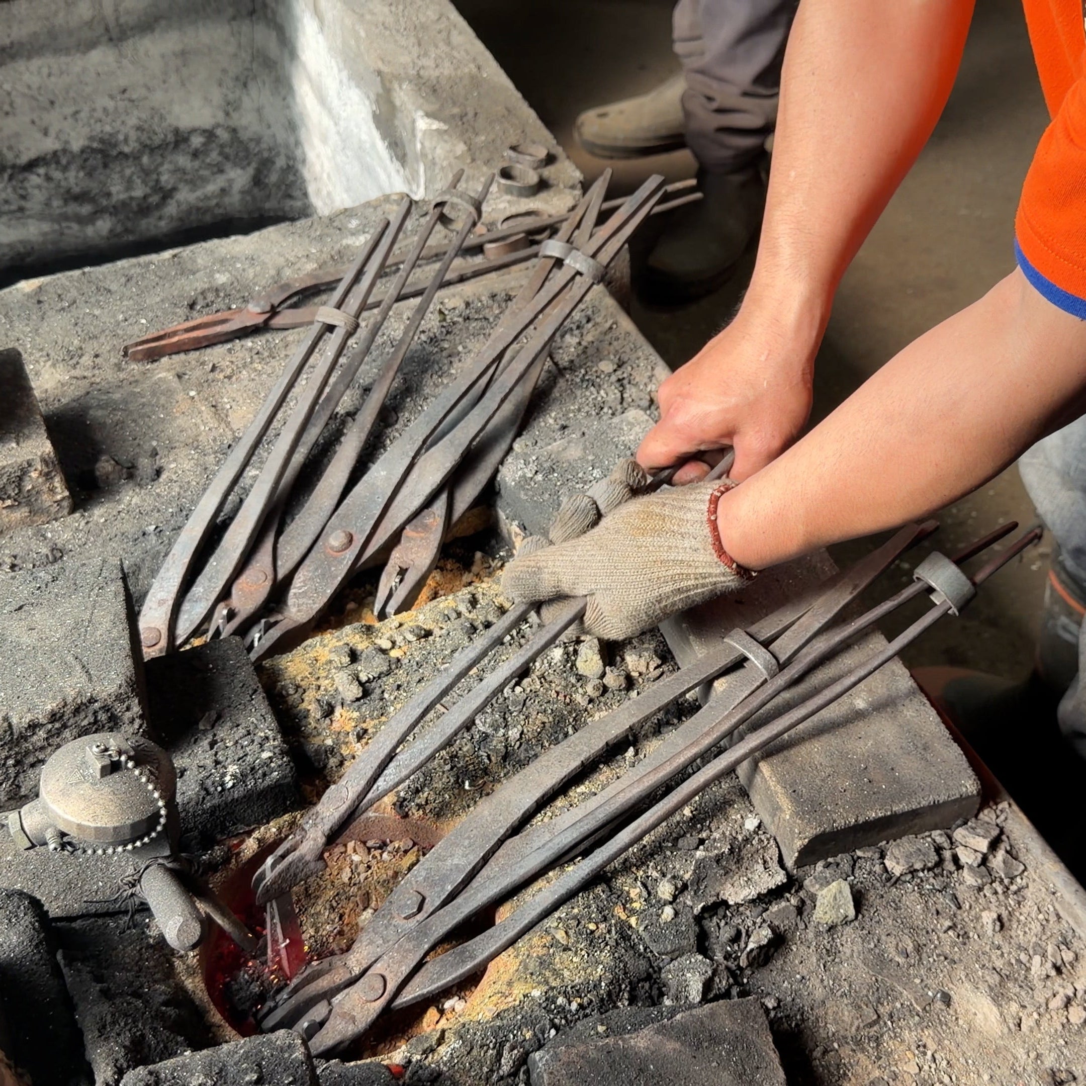 Closeup of the arms of a Sakoda Hamono artisan working in the blacksmith workshop