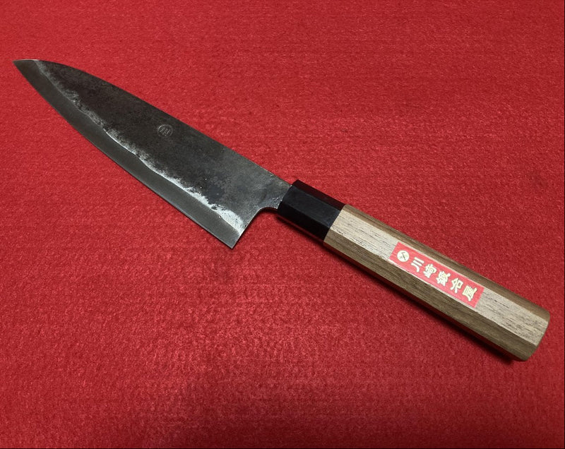 Kurouchi Gyuto Kitchen Knife 180mm crafted by Kawasaki Blacksmith diagonal on red background (front)