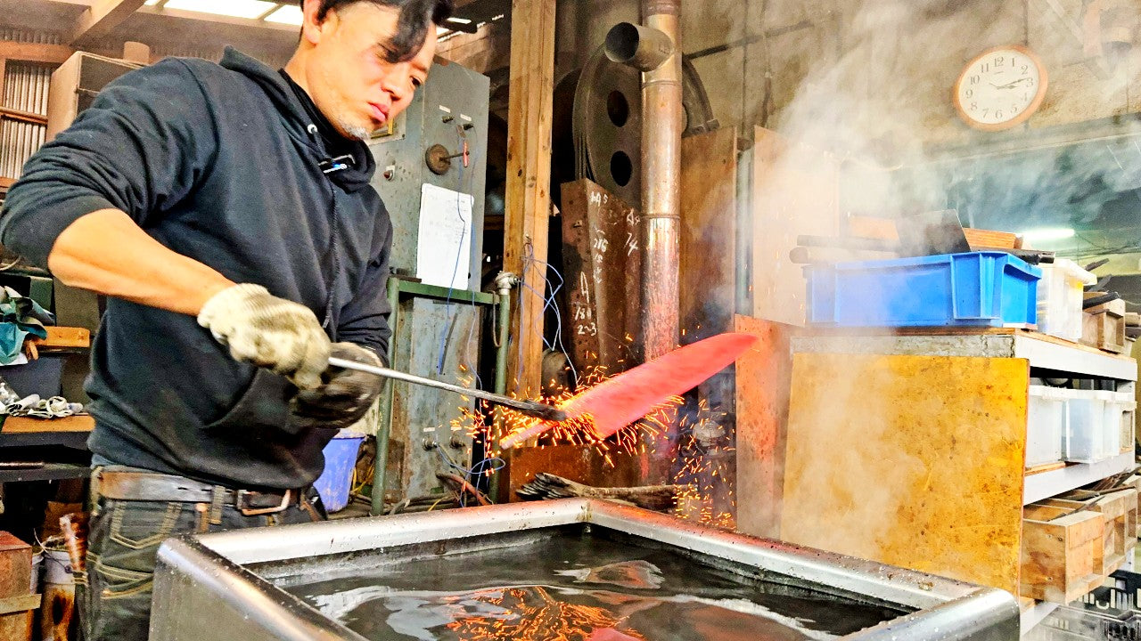 Kurotori Blacksmith craftsman performs hardening process for a blade