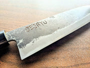 Closeup of an engraved blade of a Minomo Blacksmith Santoku Knife in latin characters