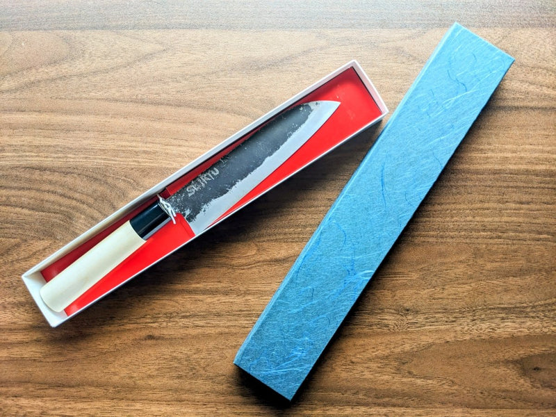 Minomo Blacksmith Santoku Knife with engraved blade inside its packaging