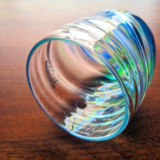 Handcrafted Cobalt Green Wavy Glass by Soejima Glassware displayed on its side on reddish brown background