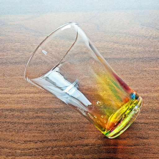 Handcrafted Rainbow Water Glass by Soejima Glassware shown diagonally on wooden background