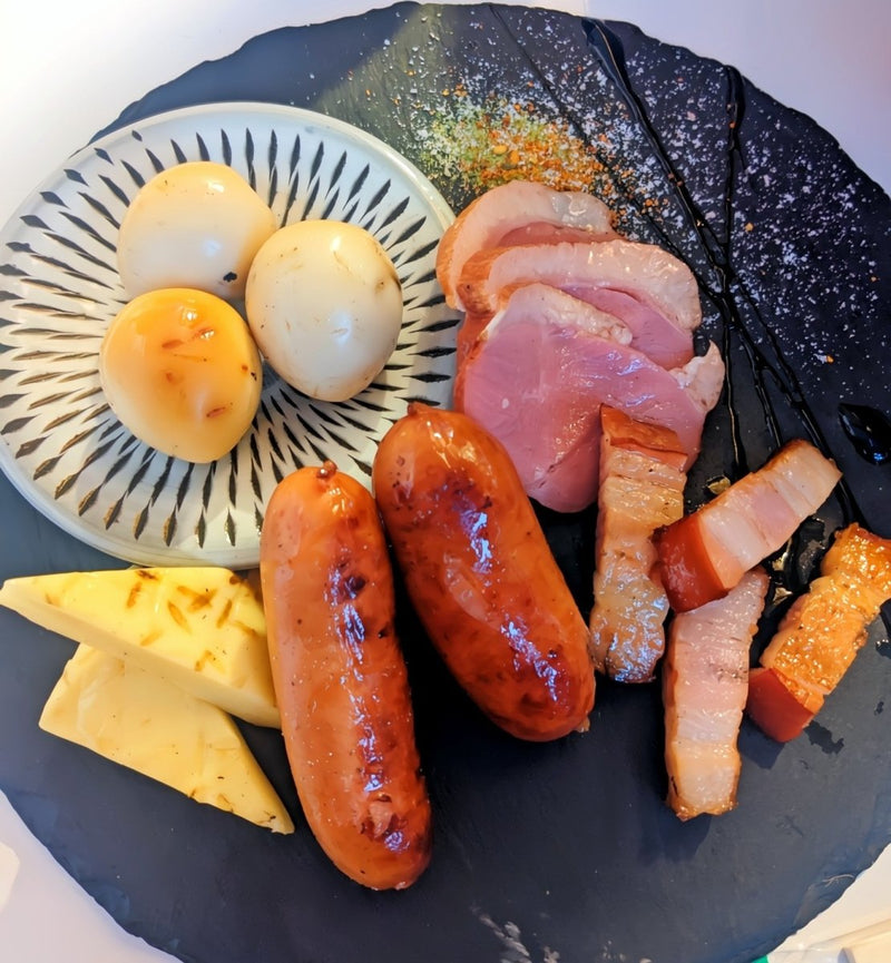 ウズラの卵、ソーセージ、チーズ、ベーコン、鴨肉が入った燻製前菜セットの上の視点