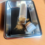 Closeup on gold power included in Kintsugi Repair Kit by Kintsugi Kurashi displayed on metal tin on wooden table