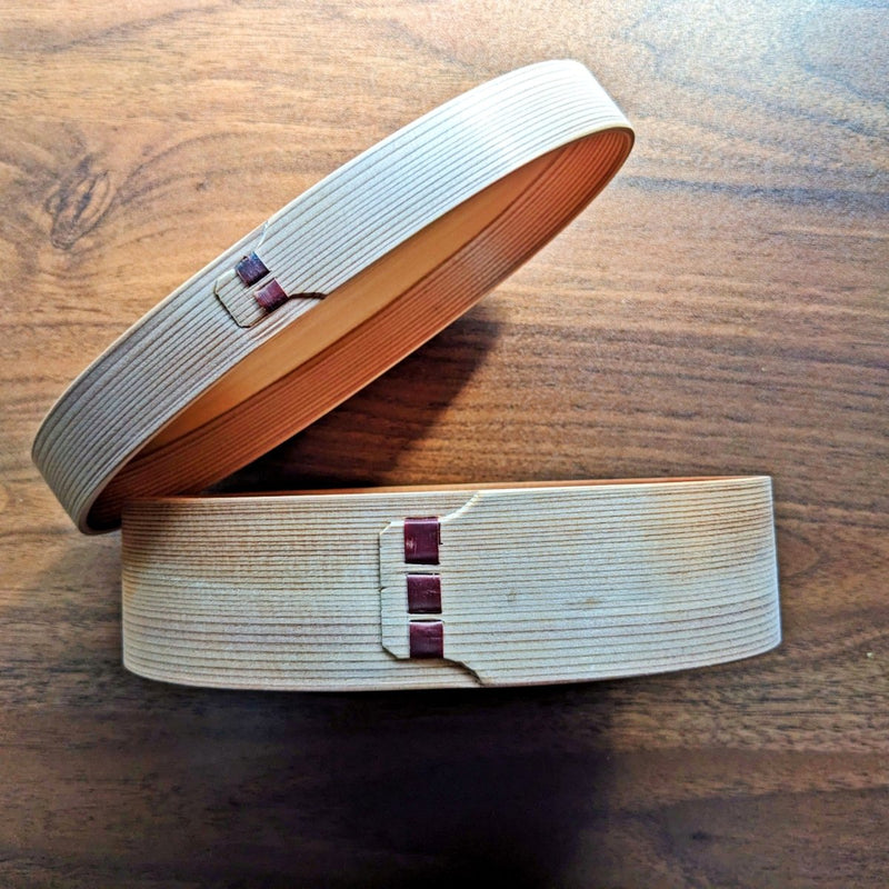 Side profile of open Oval Bento Box crafted by Hakata Bentwood Tamaki on wooden background