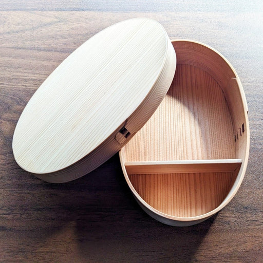 Empty Oval Bento Box crafted by Hakata Bentwood Tamaki open showing outside of lid on wooden background