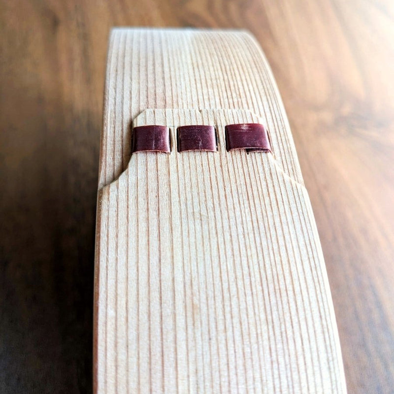 Closeup on side detailing on Oval Bento Box crafted by Hakata Bentwood Tamaki on wooden background