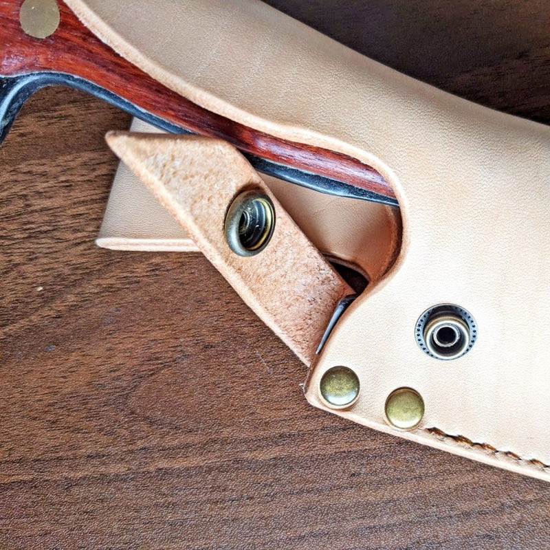 Closeup on strap for Leather case for Kurotori Butcher Knife on wooden background