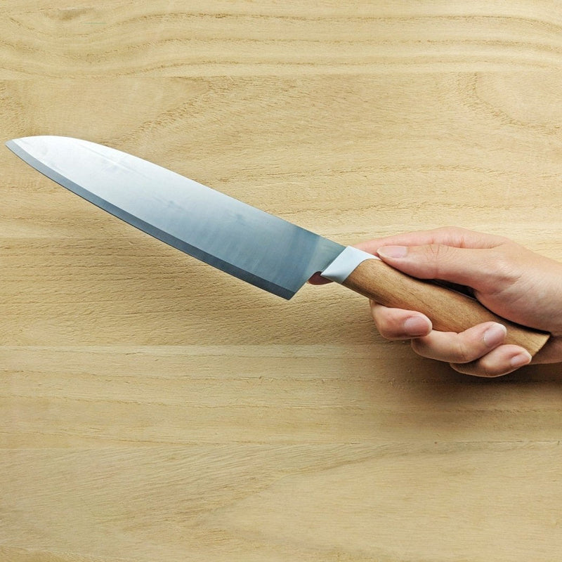 Hand holding KISEKI Santoku Knife by Fukuda Hamono