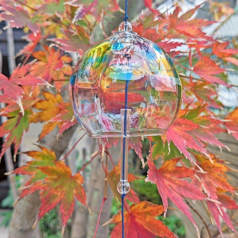 屋外の紅葉の前に垂直に吊るされた副島ガラスの手作りレインボー風鈴