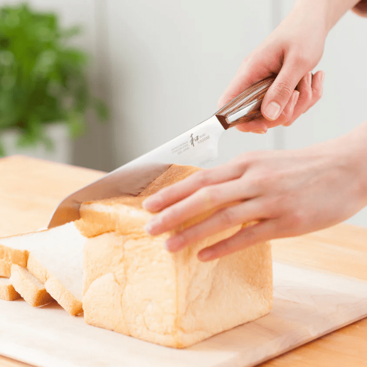 Hands slicing bread with NAGOMI Bread Knife 205mm by Mitsuboshi Cutlery