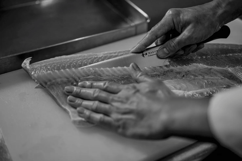 Chef cutting fish with NAGOMI PROFESSIONAL Slicing Knife 240mm by Mitsuboshi Cutlery