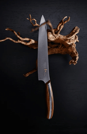 NAGOMI Petty Knife 155mm crafted by Mitsuboshi Cutlery with piece of wood on black background 