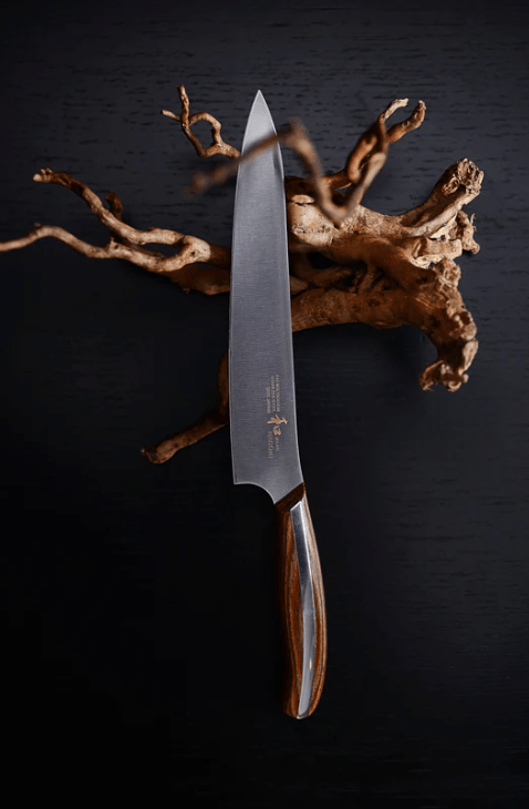 NAGOMI Petty Knife 155mm crafted by Mitsuboshi Cutlery with piece of wood on black background 
