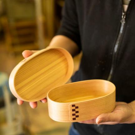 Closeup of the artisans hand holding an opened Bento Box Checked Pattern by MOCKATS