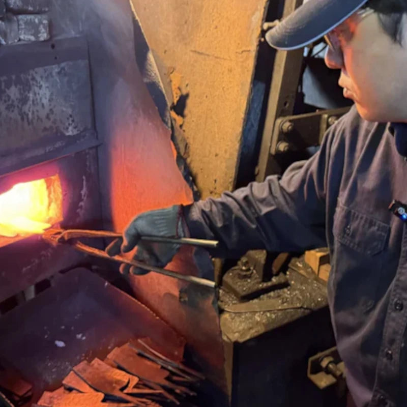Kajihara Hamono master artisan pulling a blade out of the fire