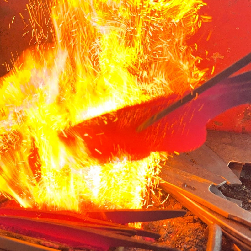 Closeup of hammer being heated in the fire in the Kurotori Blacksmith workshop
