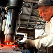 Nakamura Blacksmith hammering a blade inside his workshop